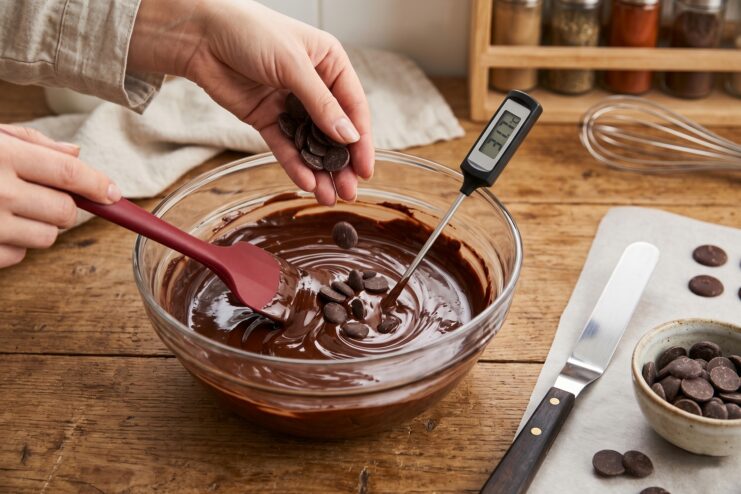Seeding Method with Callets Adding chocolate callets to melted chocolate with a thermometer