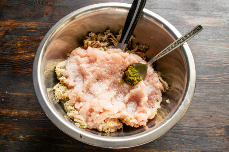 Seasoning the Sausage Adding spices and chili paste to the minced chicken mixture