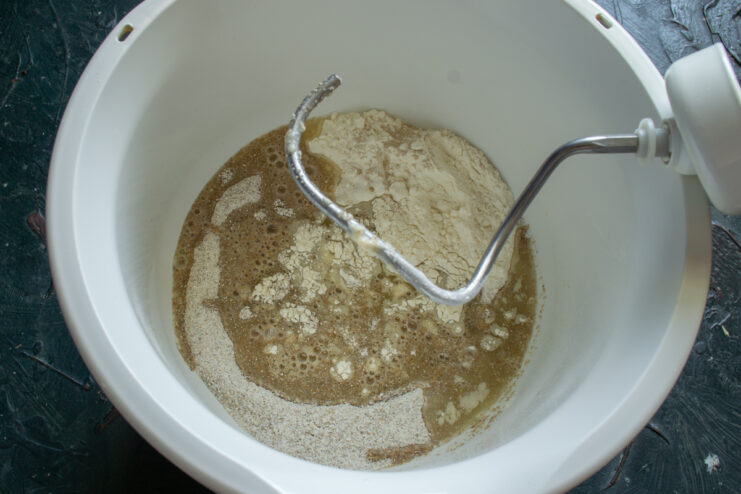 Combining the ingredients Pouring liquid honey and whey mixture into dry flour ingredients