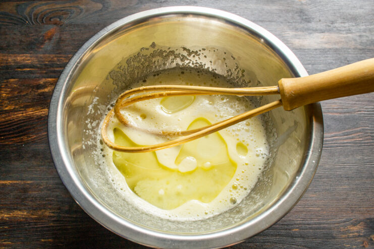 Pouring warm milk and melted butter Pouring warm milk and melted butter into the whisked egg mixture