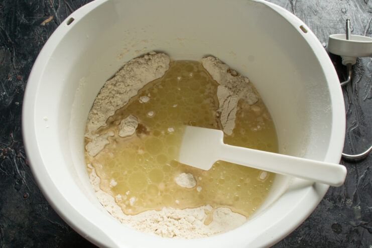 Adding whey and oil Pouring whey and olive oil into the dry flour mixture