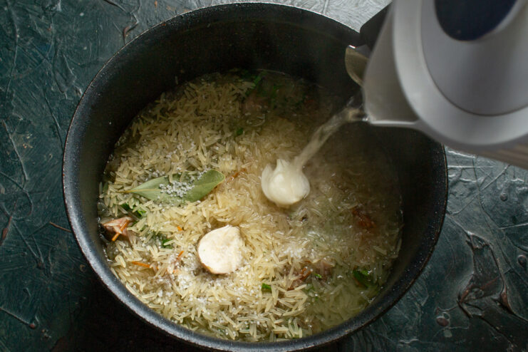 Pouring Water Over Rice Adding water and garlic to rice