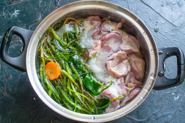 Covering with water Pouring water into a pot with chicken gizzards