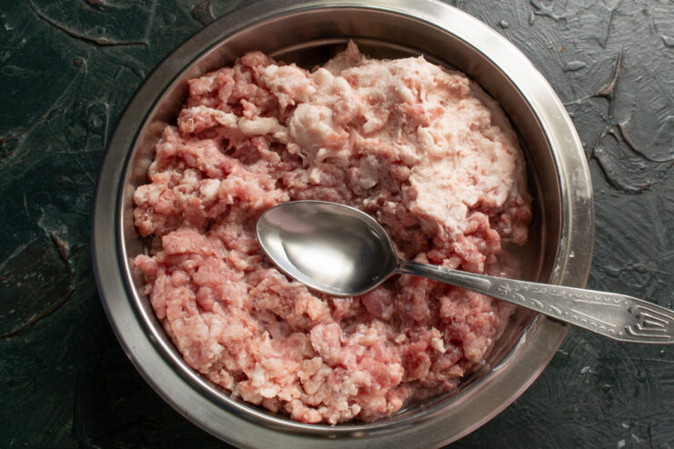 Adding water Adding water to ground meat with a spoon