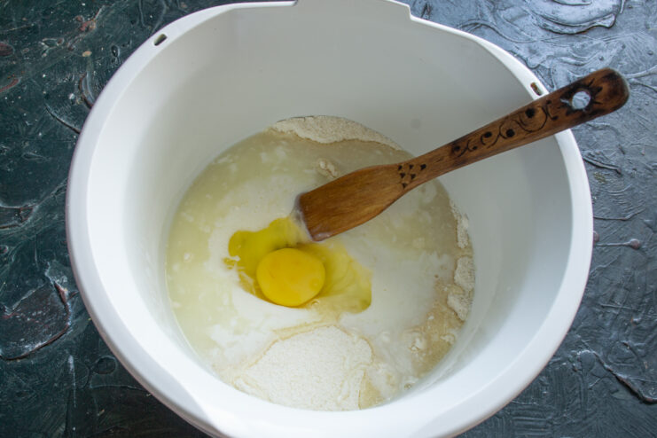 Adding Liquid Ingredients Adding a fresh egg and pouring kefir into the cake batter