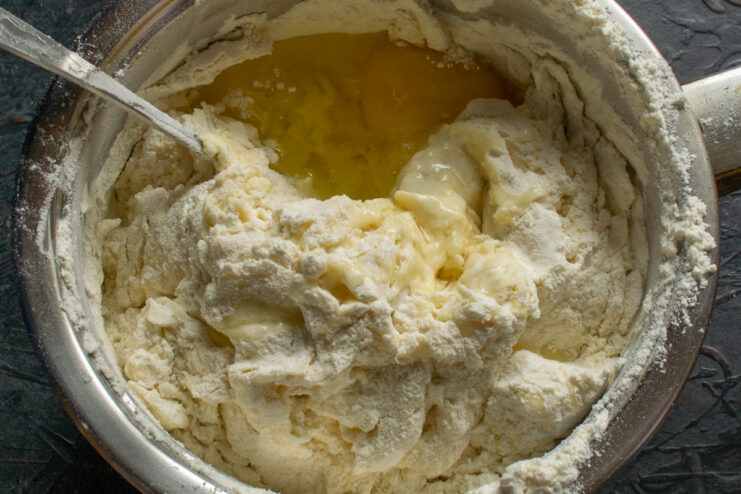 Mixing the Dough Adding an egg to the dough mixture