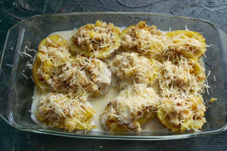 Adding grated cheese Sprinkling grated cheese over stuffed potatoes
