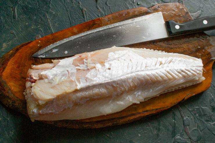 Filleting the fish Skinless cod fillets laid out on a cutting board