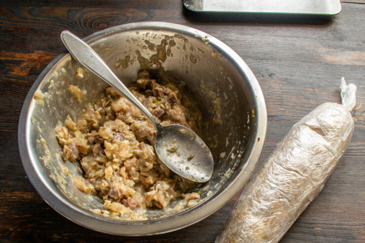 Wrapping In Plastic Rolling raw chicken sausage mixture tightly in plastic wrap