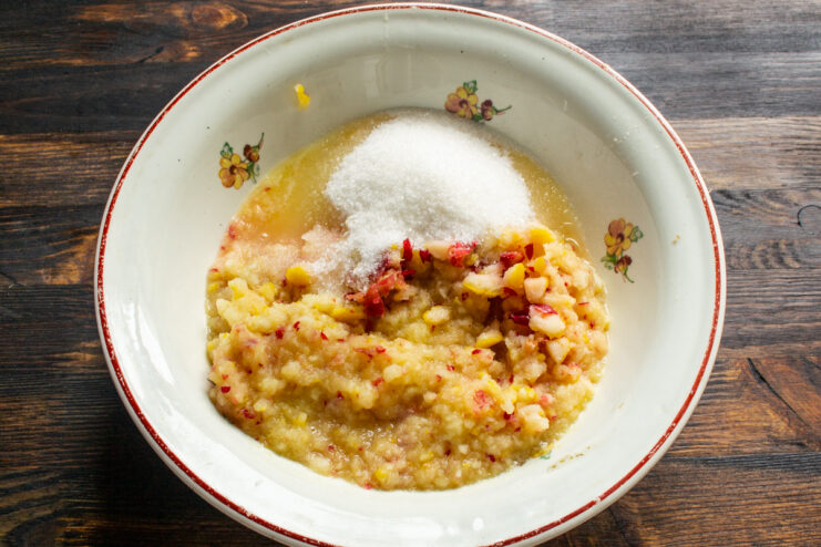 Mixing fruit purée with sugar Apple and lemon purée mixed with sugar in a bowl.