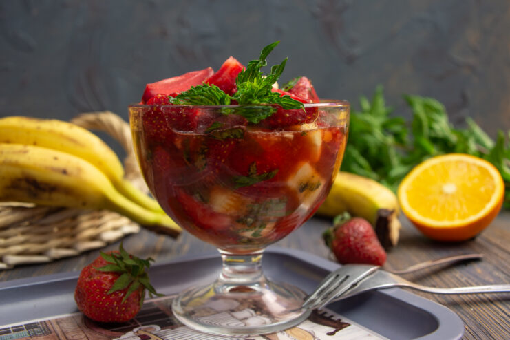 Fruit salad with strawberries and banana in a glass serving bowl