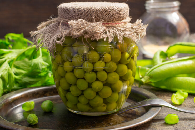 Jar of vinegar-free canned green peas on a table