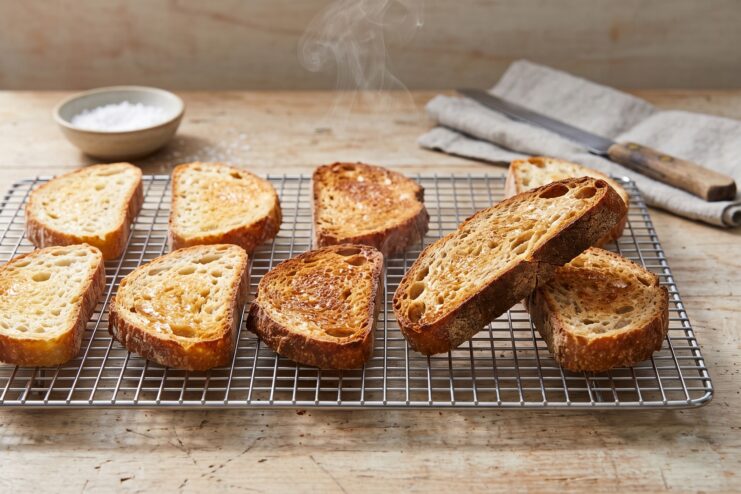 Cooling toasts on a wire rack Hot toasted bread slices cooling on a metal wire rack with rising steam
