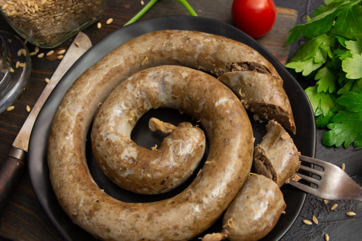 Sliced homemade chicken liver and pearl barley sausage arranged on a serving plate