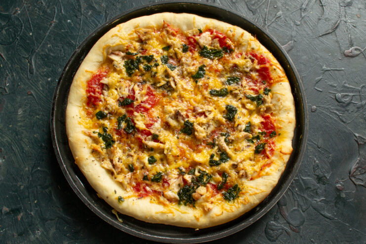 Freshly baked pizza Baked golden pizza in a round pan straight from the oven