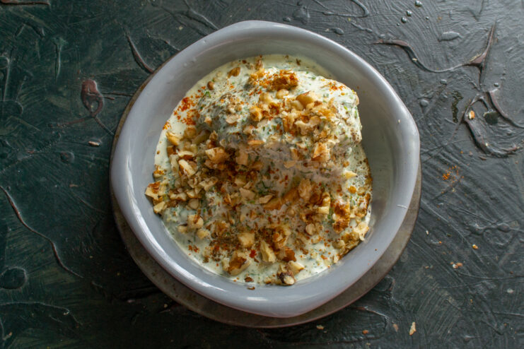 Garnishing the dish with walnuts Finished chicken dish generously sprinkled with chopped walnuts.