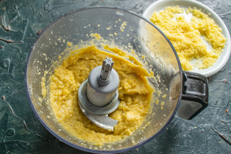 Thick, blended dough for the corn puff cakes in a food processor
