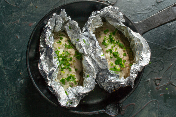 Resting the baked chicken breast Freshly baked chicken breast resting in open foil before serving.