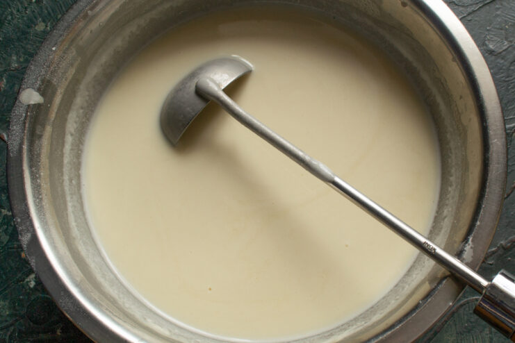 Smooth And Lump-Free Batter Smooth liquid crepe batter in a bowl with a ladle