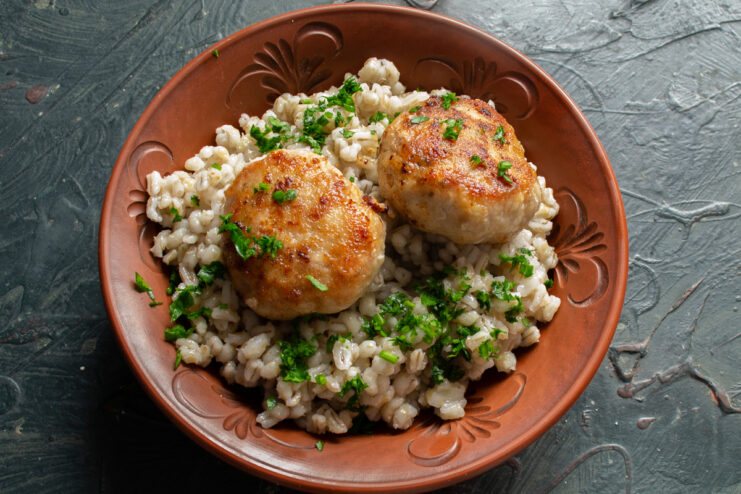 Serving the homemade patties Golden fried patties with herbs and pearl barley on a plate