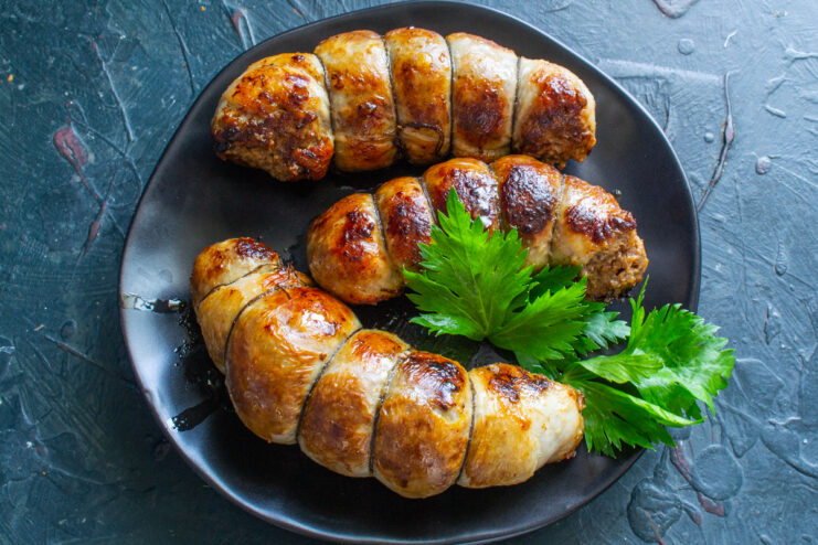 Serving Suggestions Cooked golden sausages served on a plate viewed from above