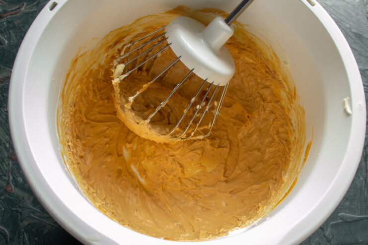 Thick buttercream with boiled condensed milk in a mixer bowl.