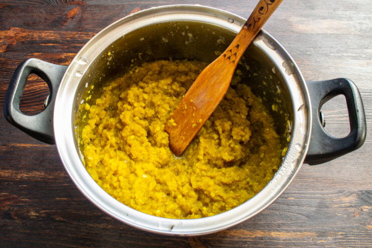 Simmering and Reducing the Sauce Thick bubbling golden apple sauce simmering in a heavy-bottomed pot