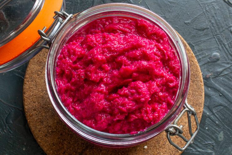 Packing horseradish into jars Finished beet and horseradish sauce packed tightly into a sterilized glass jar.