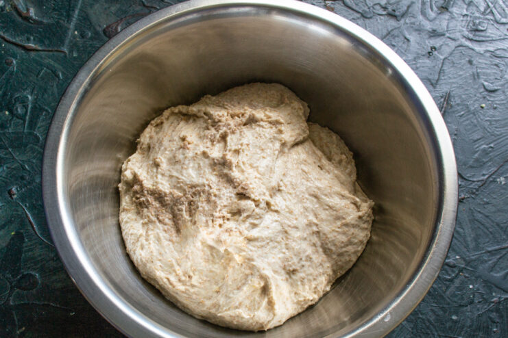 Dough Before Proofing Bread dough placed inside a deep metal mixing bowl greased with oil.