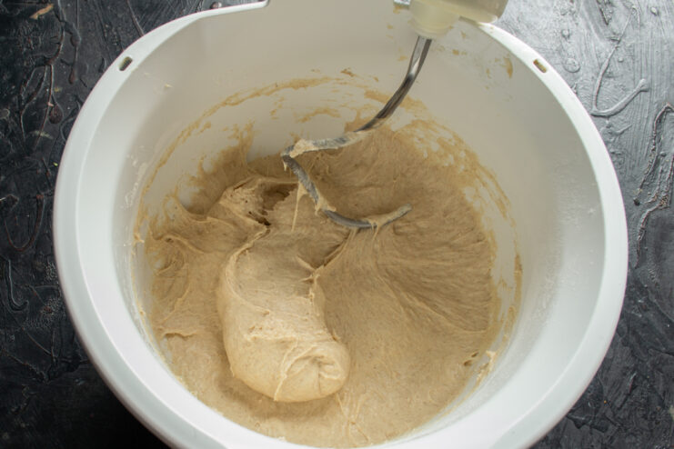 Developing gluten in mixer Smooth and elastic kneaded dough pulling away from the mixer bowl walls