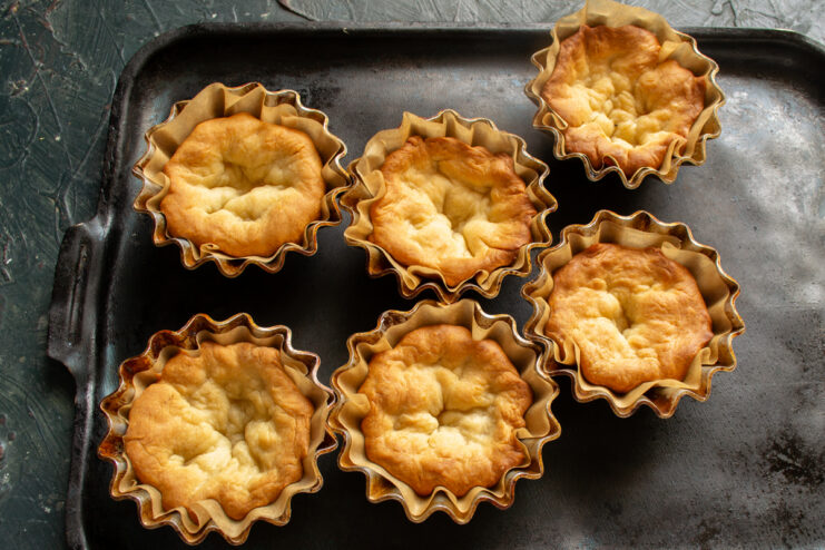 Golden Baked Pastry Shells Freshly baked golden pastry shells resting in metal baking molds