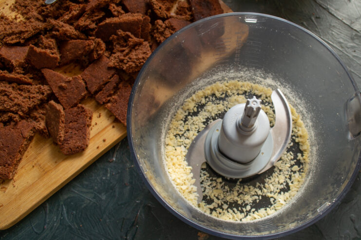 Grinding almond flakes in a blender bowl.
