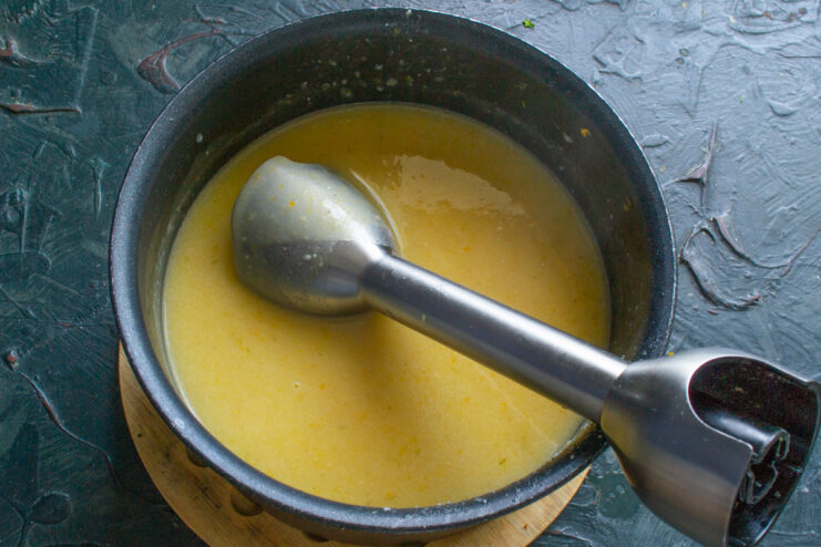 Puréeing vegetable soup with an immersion blender directly in the cooking pot