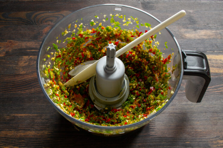 Initial mincing Minced green and red peppers with garlic in a food processor bowl.