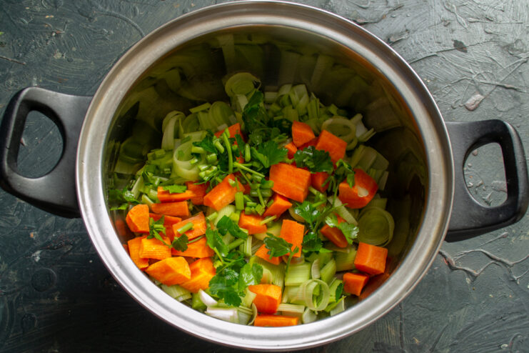 Adding fresh herbs Chopped parsley and celery added to the pot with vegetables