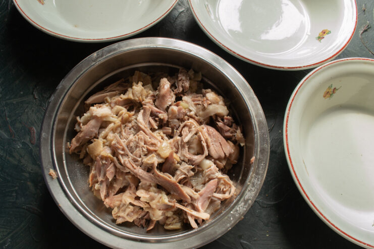 Shredding the Meat Shredded pork meat in a metal bowl.