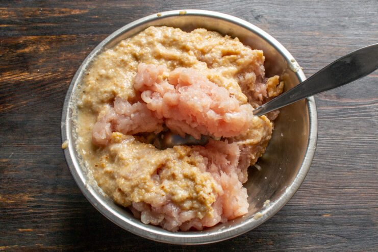 Grinding the meat and bread Ground chicken mixture in a stainless steel bowl