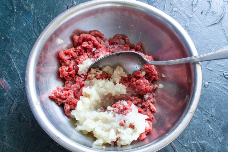 Adding The Onion Minced onion added to the bowl of ground beef