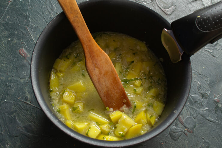 Potatoes and vegetables gently boiling in a small amount of fish broth.