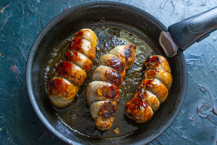 Simmering Under A Lid Sausages finishing cooking in a covered skillet