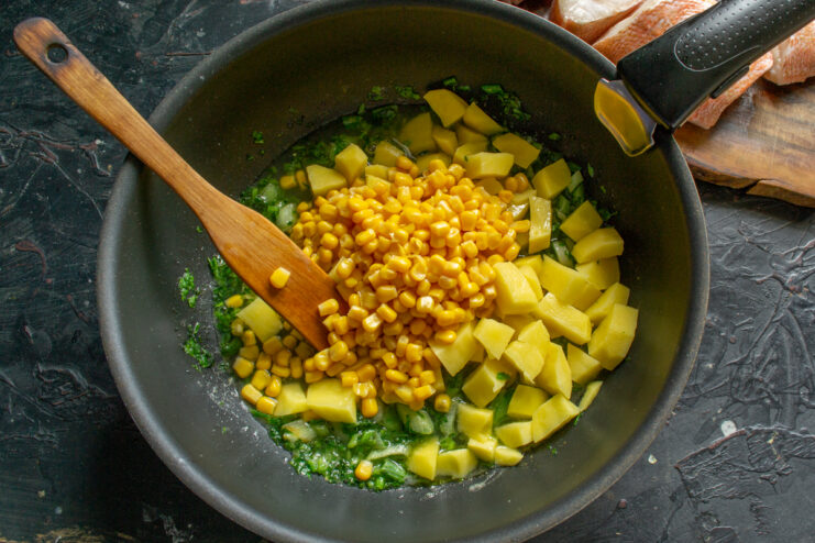 Stirring in Sweet Corn Canned sweet corn added to the soup pot with vegetables