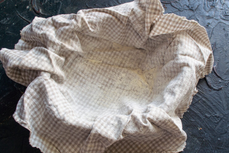 Preparing The Proofing Basket Bread proofing basket lined with a linen cloth and dusted with flour.