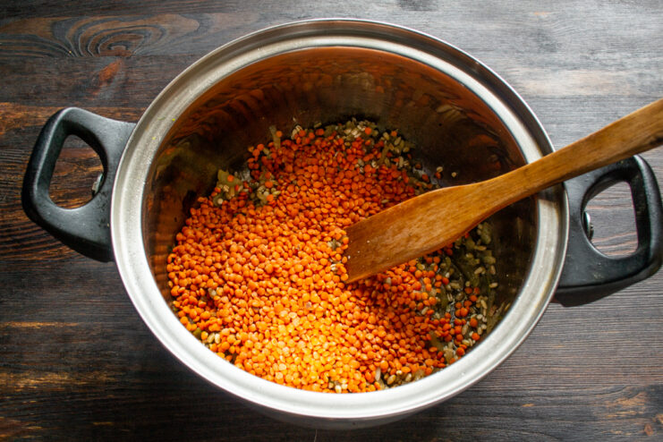 Adding dry red lentils on top of the pearl barley mixture