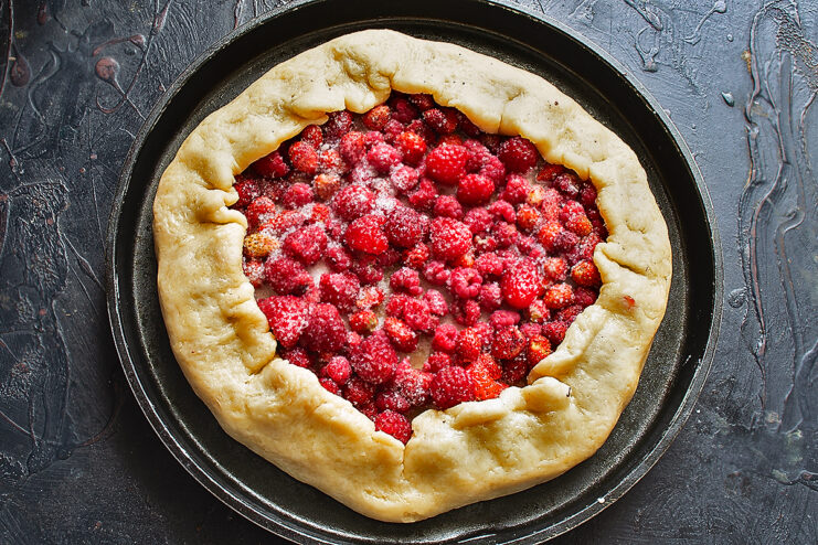 Folding the galette edges. Carefully folding the dough edges over the fresh berry filling