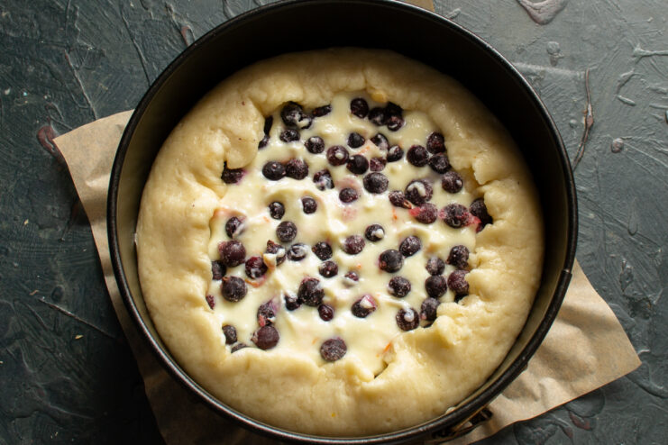 Edges of the dough folded over the berry filling in a baking pan