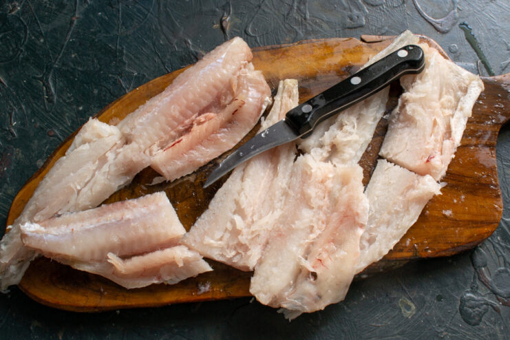 Fish fillets for the soup Large chunks of raw fish fillet on a wooden cutting board ready for marination