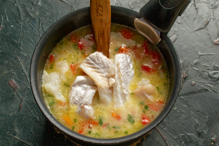 Adding the cod fillets Large chunks of cod fillet added to a soup pot