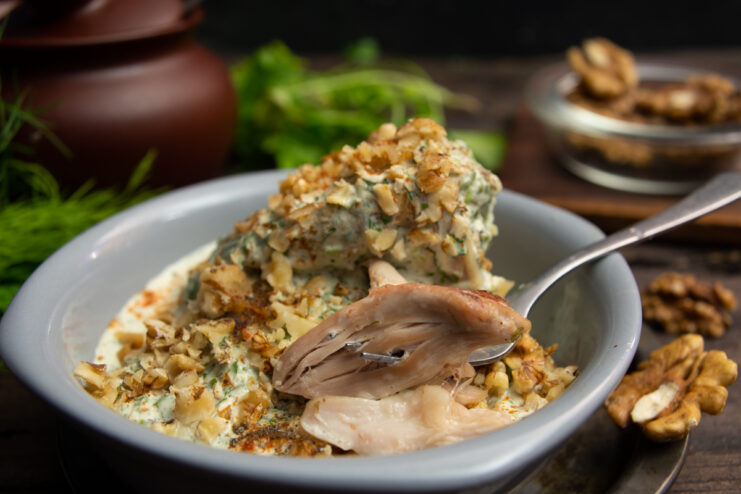 Chicken with sour cream and walnuts served in a gray plate.