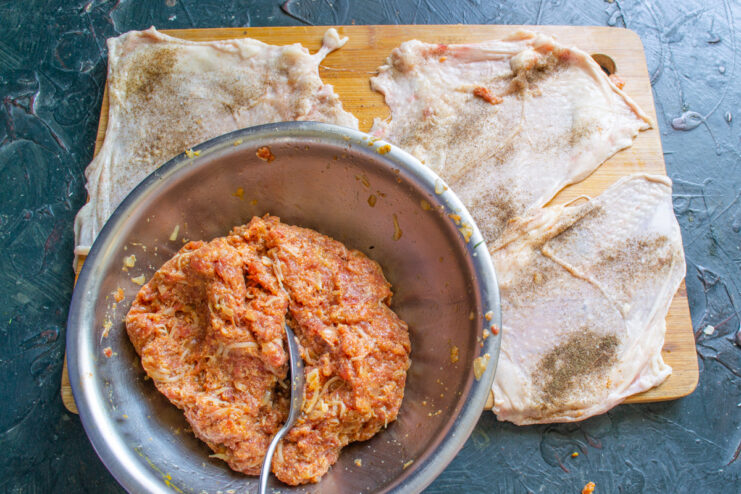 Preparing The Chicken Skin Raw chicken skin laid flat on a board next to the meat filling