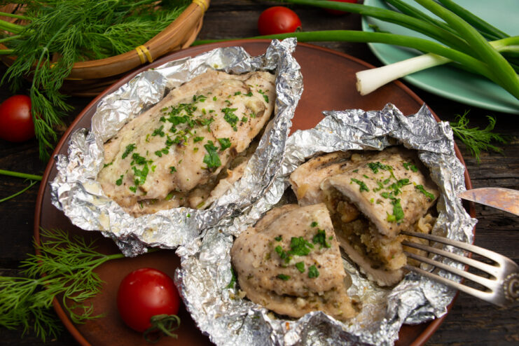Juicy sliced stuffed chicken breast with a sweet and savory filling on a plate garnished with fresh herbs.